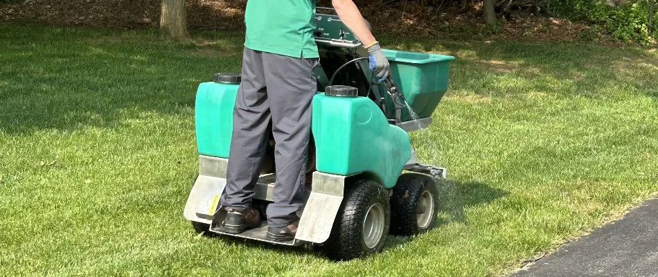 Crew applying lawn fertilizer on a lawn in Clarksville, MD.