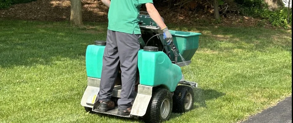 Worker in Westminster, MD, fertilizing grass.