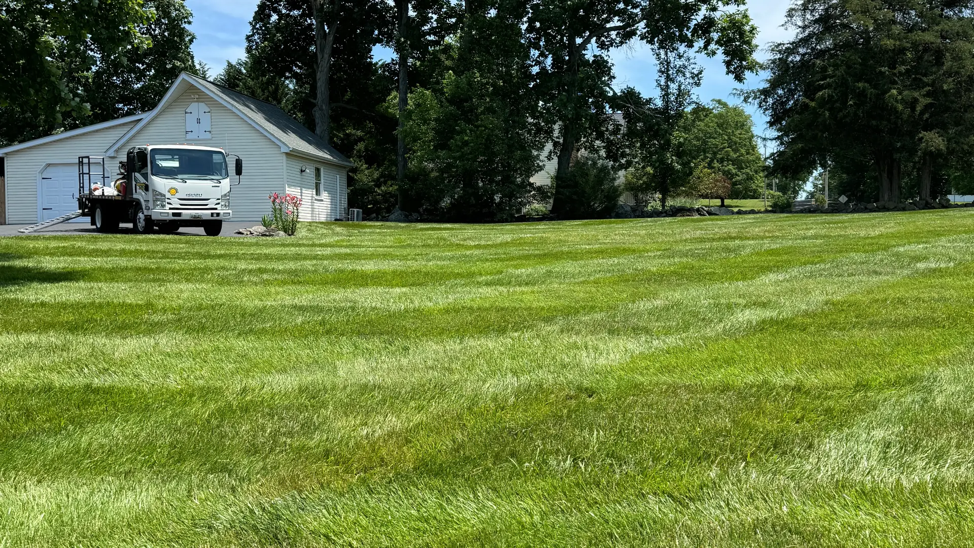 Lawn care truck by mowed grass.