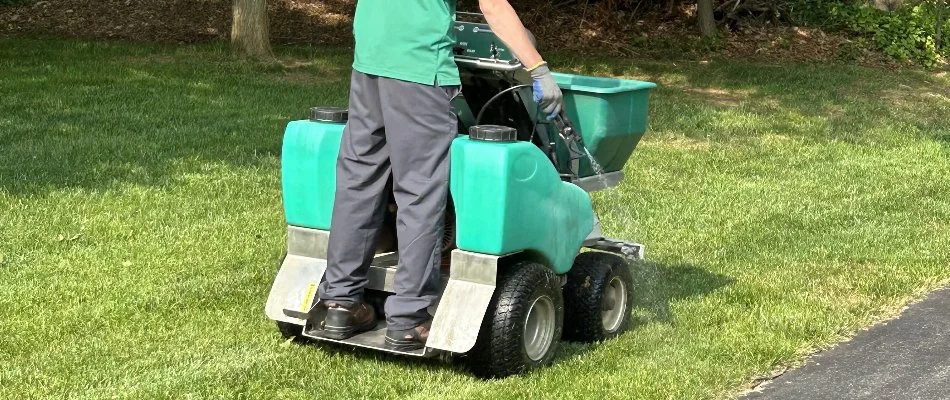 A professional applying a treatment to a lawn in Woodbine, MD.