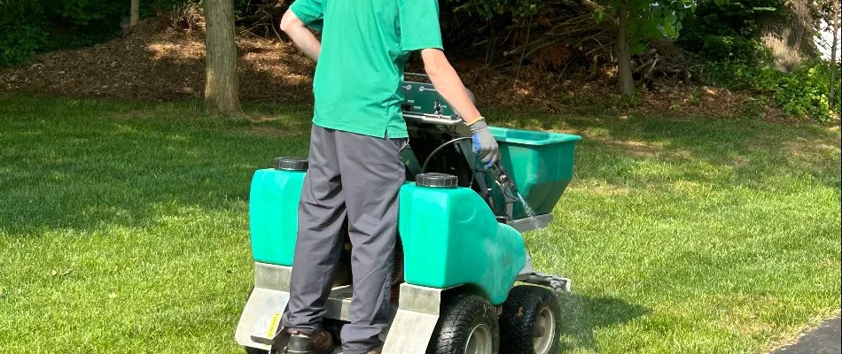 Tech spraying a lawn in Glenwood, MD, while on a granular spreader.
