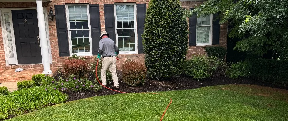 Worker in a landscape in front of a brick house in Sykesville, MD.