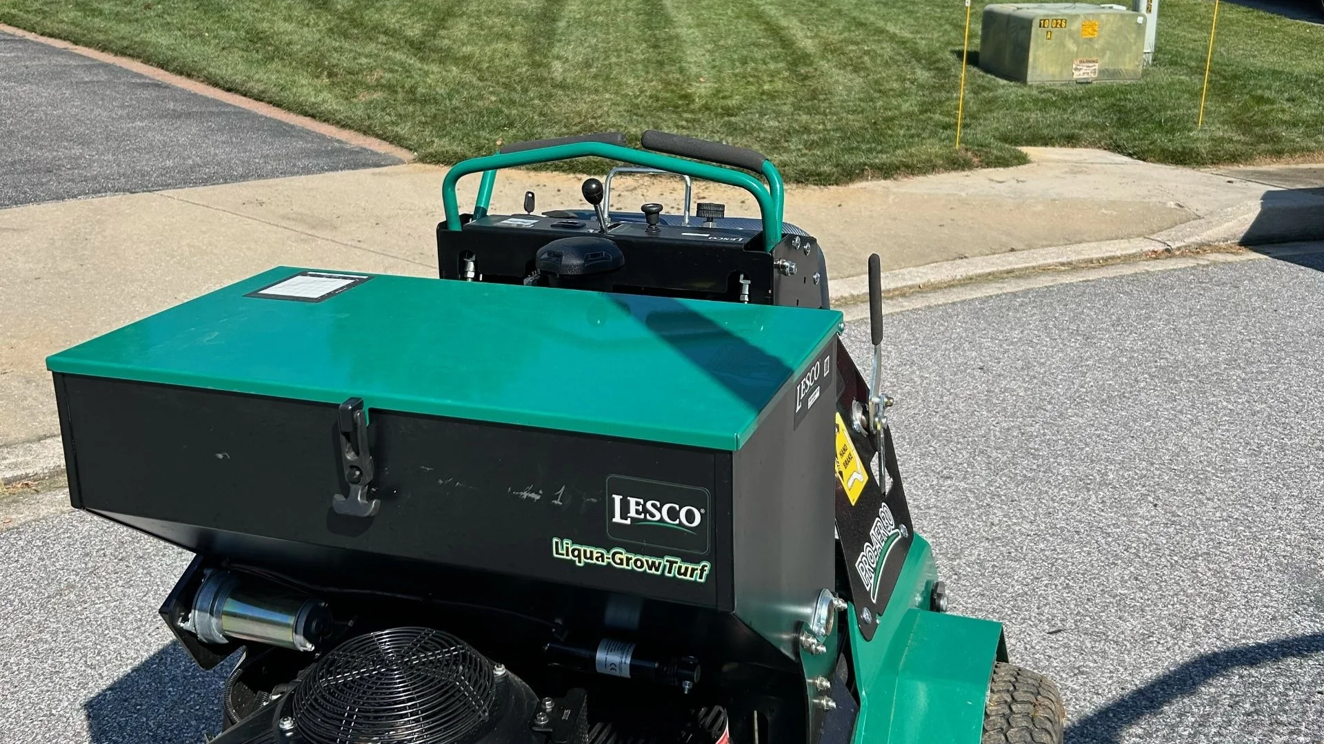 LESCO lawn care machine on a freshly mowed lawn with homes in the background.